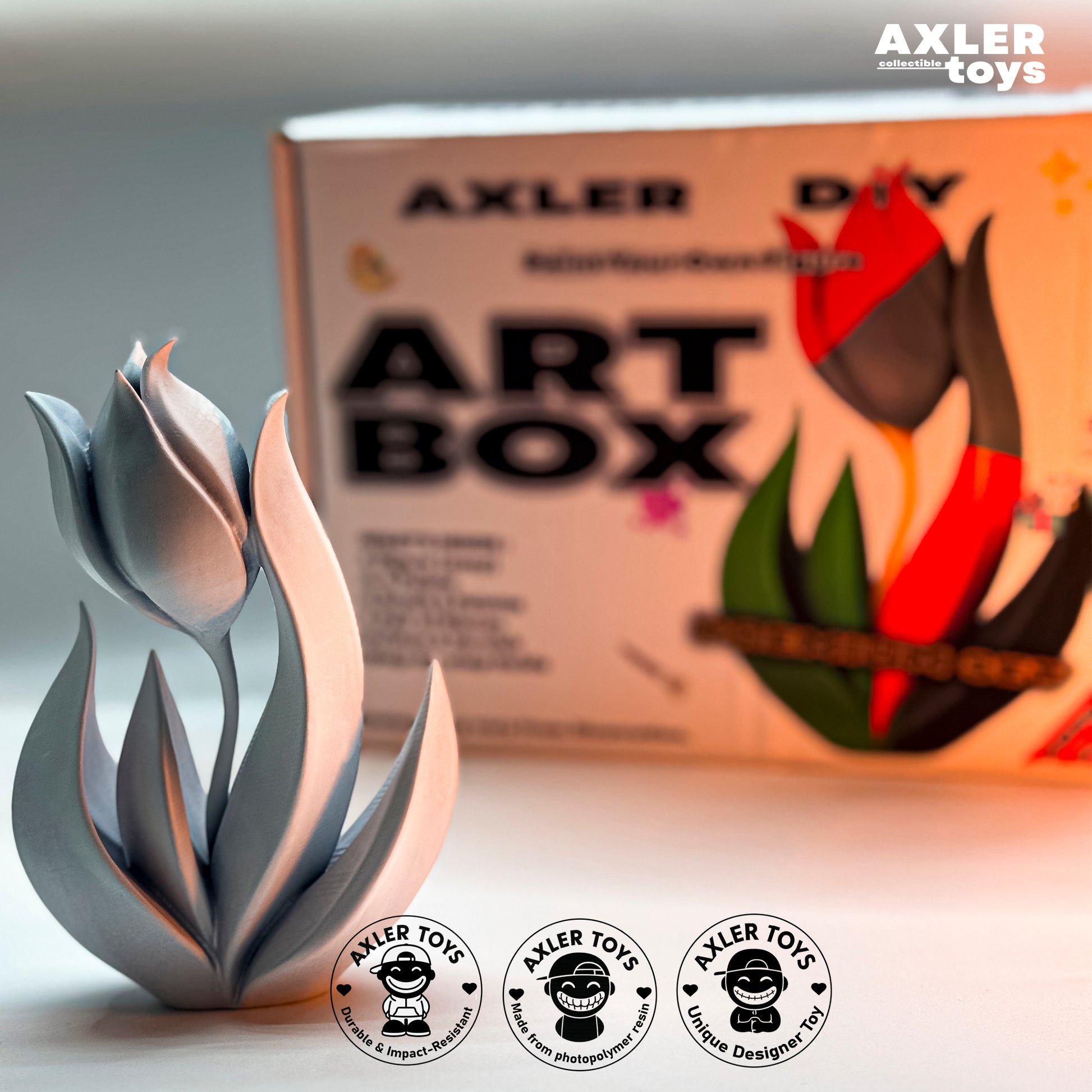Metallic sculpture in front of an 'AXLER toys Art Box' with branding visible.