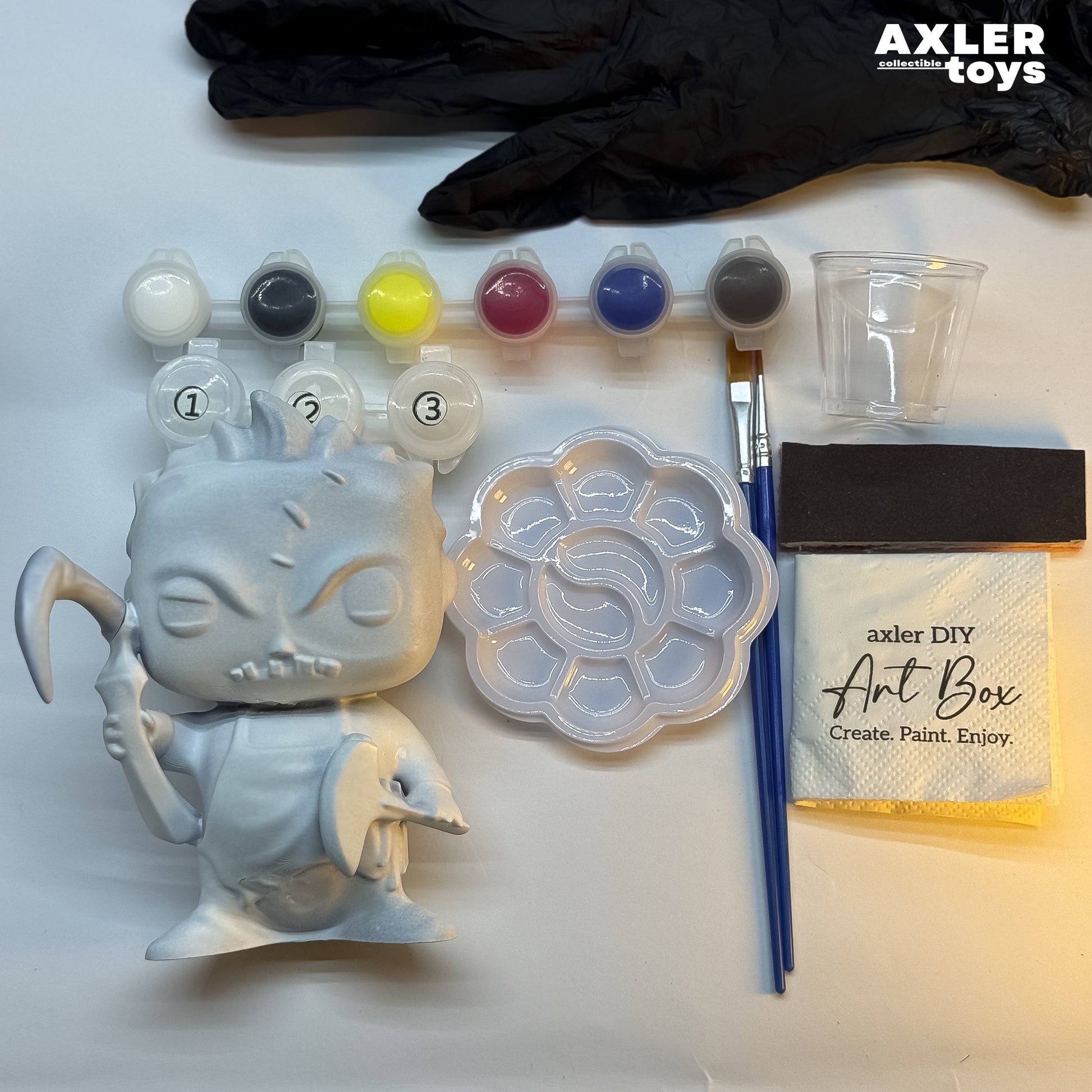 Art supplies including a mold, paint set, brushes, and a container labeled 'Axler DIY Art Box' on a white background.