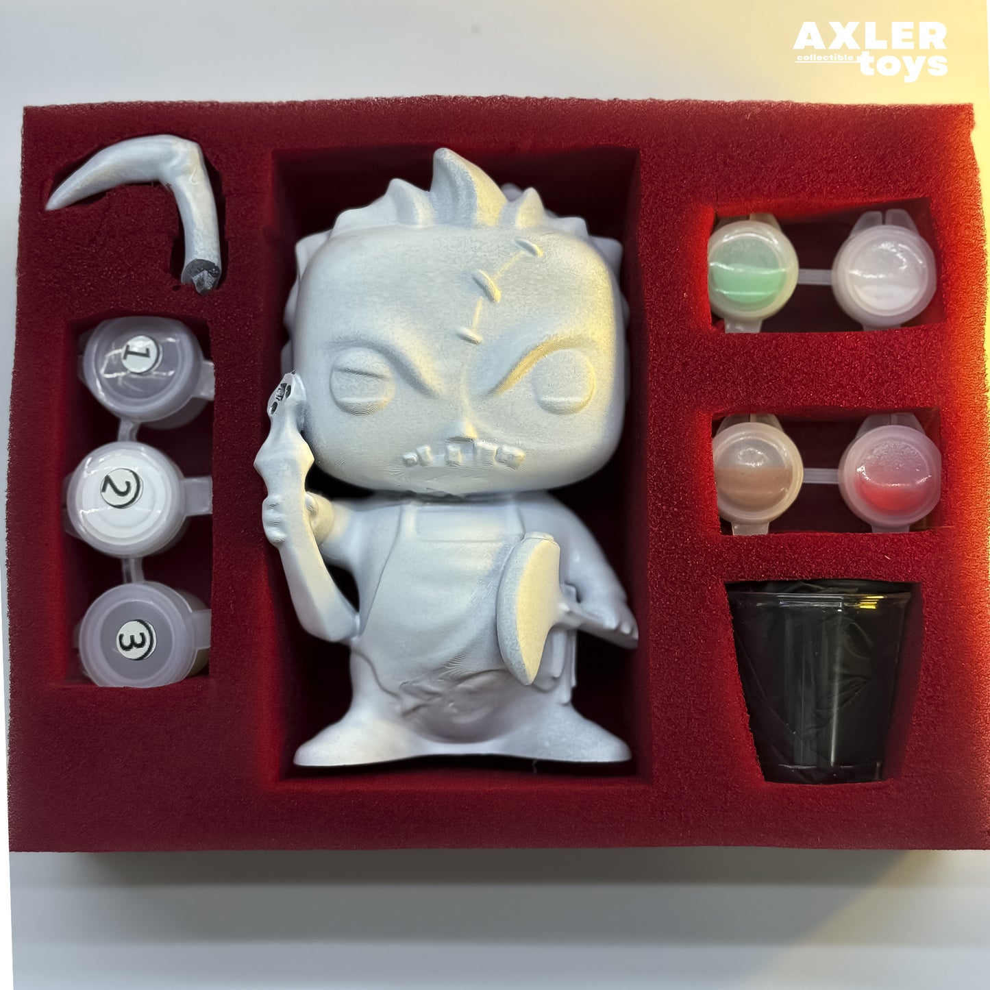 Toy figure in a red foam tray with tools, featuring the brand 'Axler Toys'.